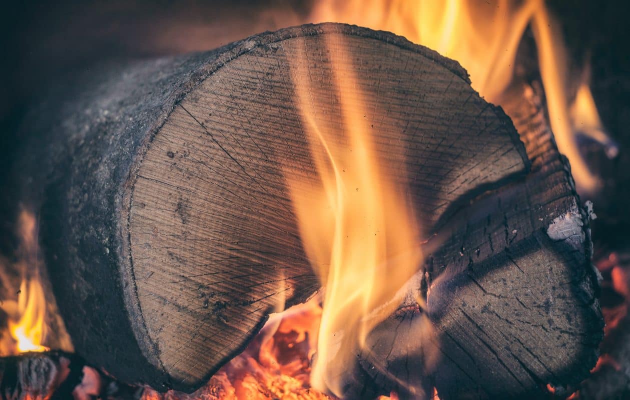 Large log burning in a darkened background